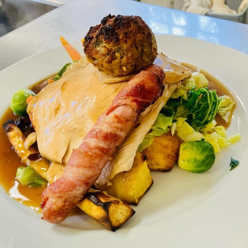 Traditional roast dinner with meat, pigs in blankets, stuffing, vegetables and gravy at The Hare Arms
