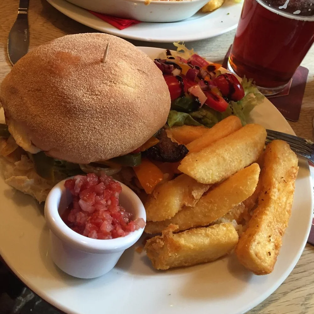 Beef burger served with chunky chips, salad and tomato relish