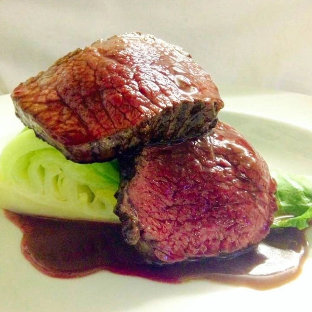 Medium-rare beef fillet served with greens and rich jus